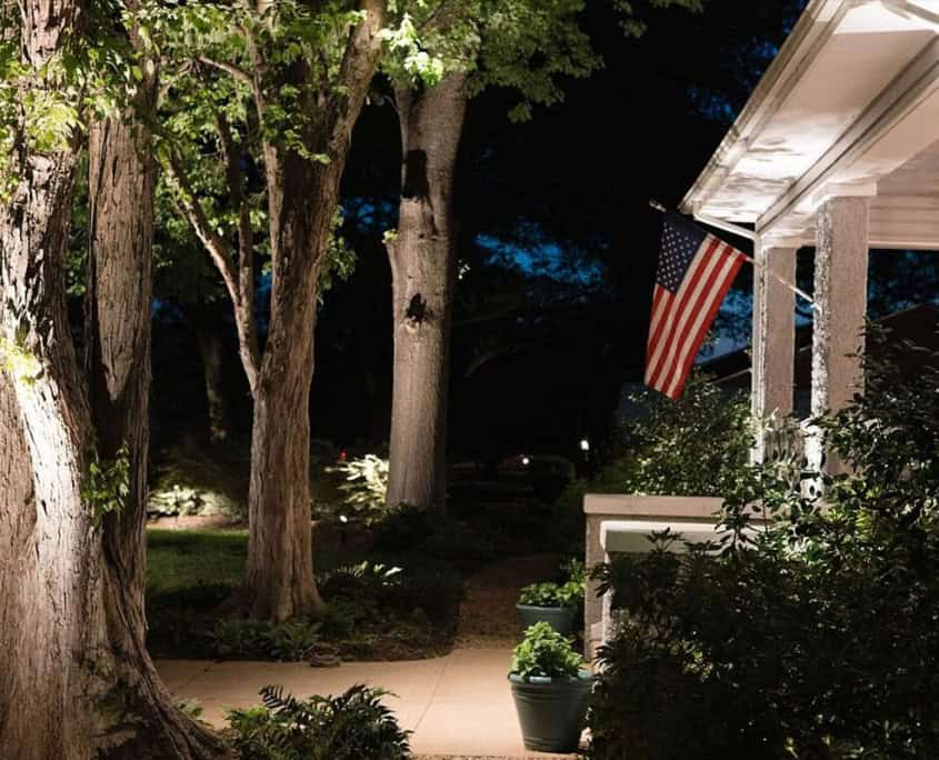 Night view of a home illuminated by landscape lighting, showcasing the 
